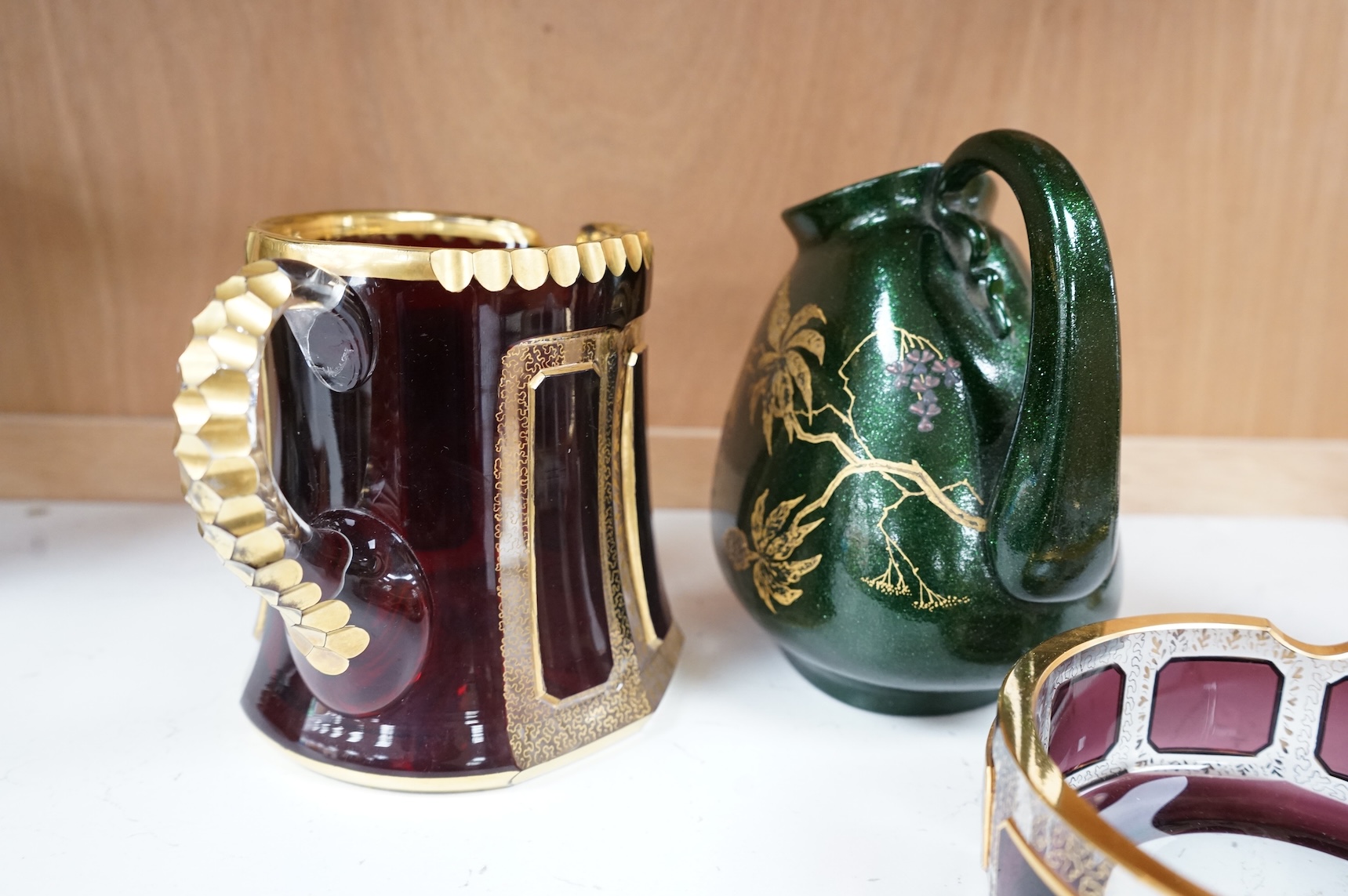 Three pieces of Bohemian and Austrian glassware comprising two jugs and an ashtray, largest 17cm high